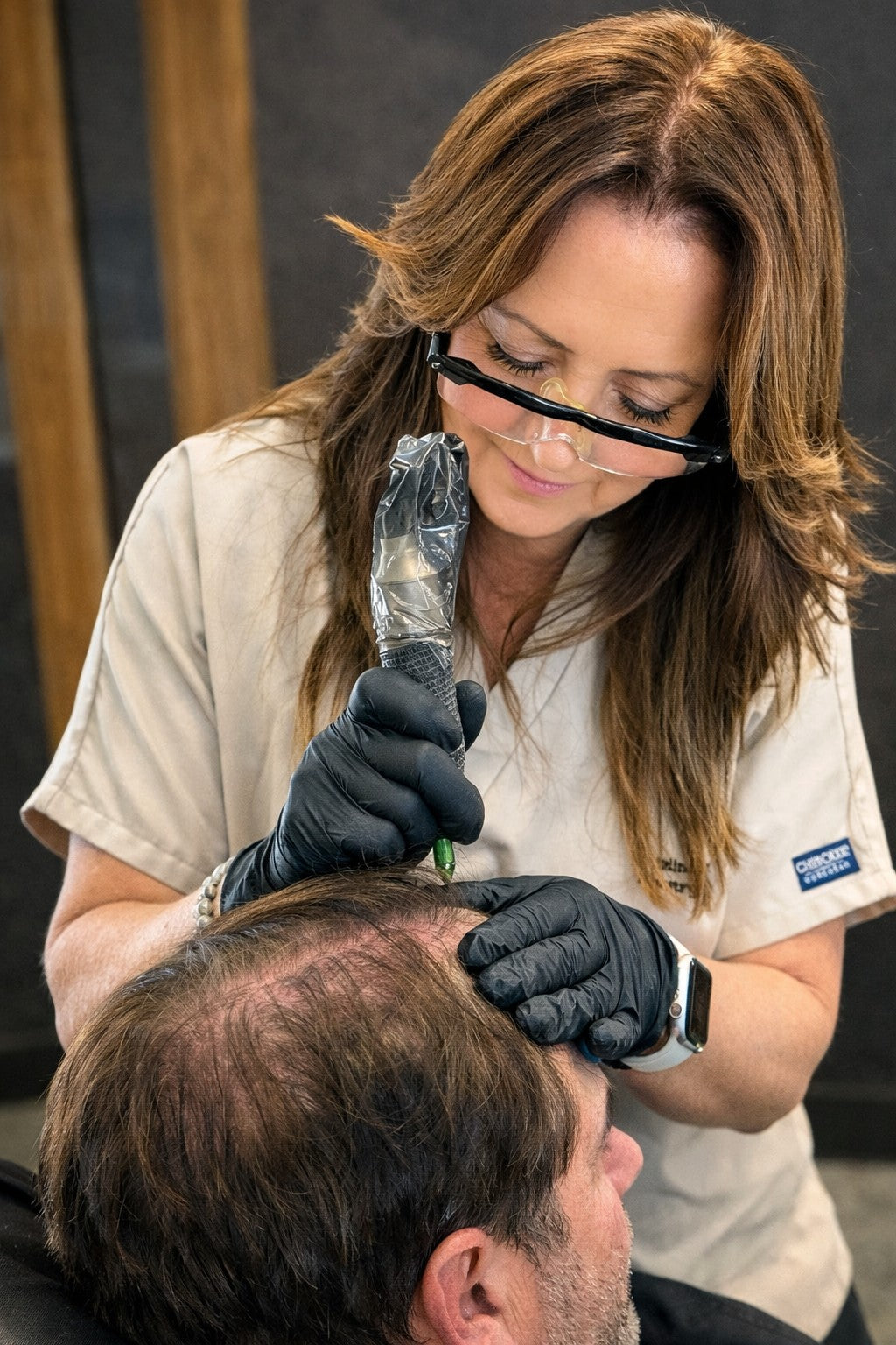 Scalp micropigmentation treatment being performed by technician on male client